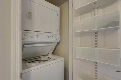 a white washer and dryer in a small bathroom at Charming PCB Condo with Balcony Walk to Beach! in Panama City Beach