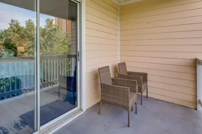 two chairs sitting on a porch next to a window at Charming PCB Condo with Balcony Walk to Beach! in Panama City Beach