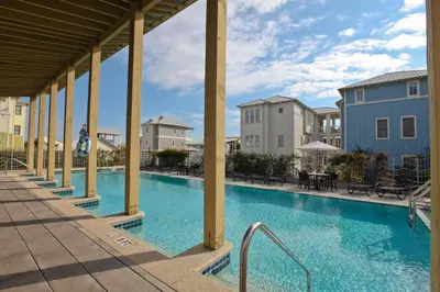 a swimming pool at a resort with tables and chairs at Conch Cottage - Lovely 2BR in Seagrove Beach in Santa Rosa Beach