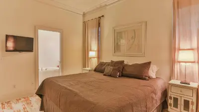 a bedroom with a bed and two windows and a television at Conch Cottage - Lovely 2BR in Seagrove Beach in Santa Rosa Beach