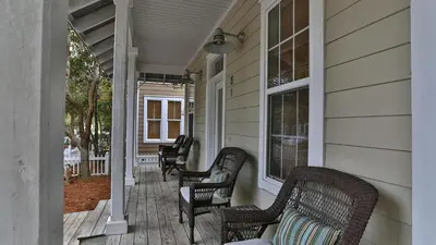 a porch with wicker chairs on a house at Conch Cottage - Lovely 2BR in Seagrove Beach in Santa Rosa Beach