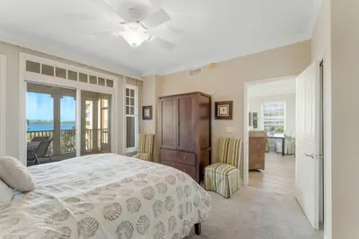 a bedroom with a bed and a balcony at Reflections at Bay Point Unit 412 (3/3) in Panama City Beach