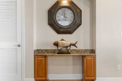 a clock hanging on a wall with a fish on a counter at Reflections at Bay Point Unit 412 (3/3) in Panama City Beach