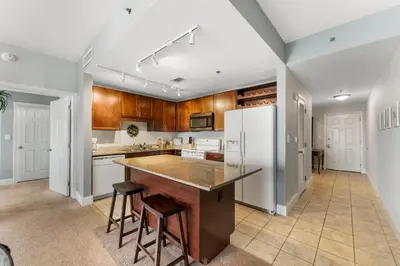 a kitchen with wooden cabinets and a large island at Laketown Wharf #311 by Nautical Properties in Panama City Beach