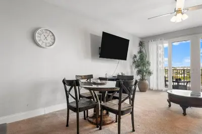 a dining room with a table and chairs and a clock at Laketown Wharf #311 by Nautical Properties in Panama City Beach