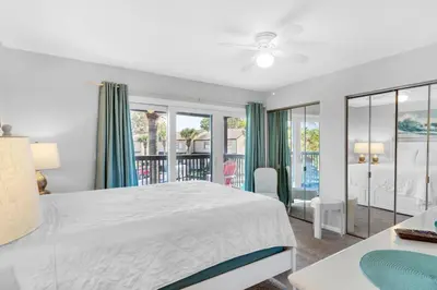 a bedroom with a large bed and a balcony at Portside I5 in Panama City Beach