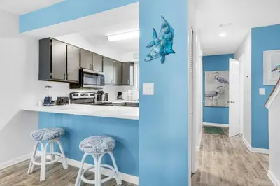 a kitchen with blue walls and stools at Portside I5 in Panama City Beach