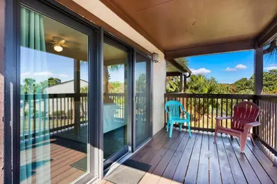 a screened porch with a chair and a table at Portside I5 in Panama City Beach