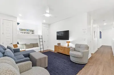 a living room with a couch and two chairs and a tv at Family Tides Beach House by Panhandle Getaways in Panama City Beach
