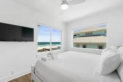 a white bedroom with a large bed and a large window at Family Tides Beach House by Panhandle Getaways in Panama City Beach