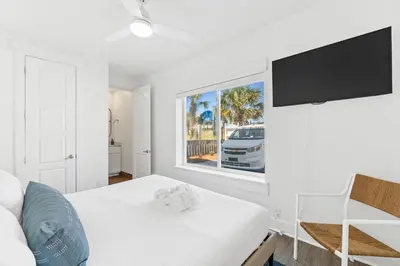 a white bedroom with a bed and a window at Family Tides Beach House by Panhandle Getaways in Panama City Beach