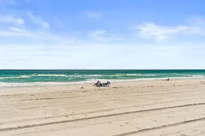 a group of people sitting on the beach at Family Tides Beach House by Panhandle Getaways in Panama City Beach