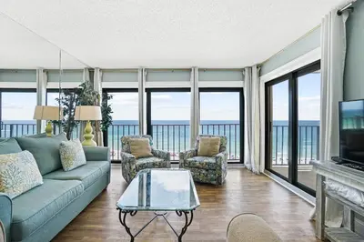 a living room with a couch and chairs and windows at Moondrifter Beach Resort by Panhandle Getaways in Panama City Beach
