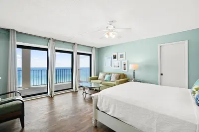a bedroom with a bed and a view of the ocean at Moondrifter Beach Resort by Panhandle Getaways in Panama City Beach