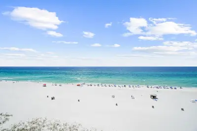 a group of people on a beach with the ocean at Moondrifter Beach Resort by Panhandle Getaways in Panama City Beach