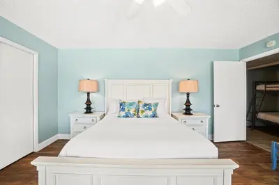 a bedroom with a white bed with two night stands at Moondrifter Beach Resort by Panhandle Getaways in Panama City Beach