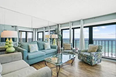 a living room with a couch and two chairs and windows at Moondrifter Beach Resort by Panhandle Getaways in Panama City Beach