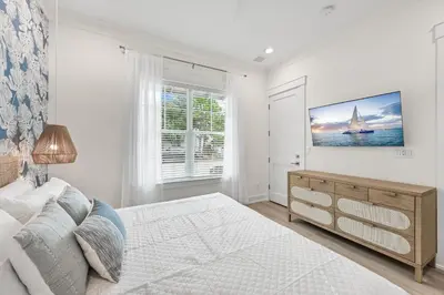 a bedroom with a bed and a tv on the wall at 30 A-mazing in Santa Rosa Beach
