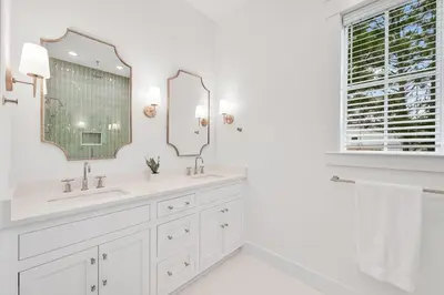 a white bathroom with two sinks and a mirror at 30 A-mazing in Santa Rosa Beach