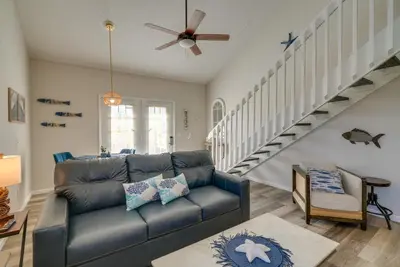 a living room with a couch and a staircase at Walk to Ocean Condo with Pool and Hot Tub in PCB! in Panama City Beach