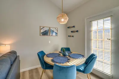 a dining room with a table and chairs and a couch at Walk to Ocean Condo with Pool and Hot Tub in PCB! in Panama City Beach