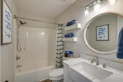 a bathroom with a sink and a toilet and a mirror at Walk to Ocean Condo with Pool and Hot Tub in PCB! in Panama City Beach