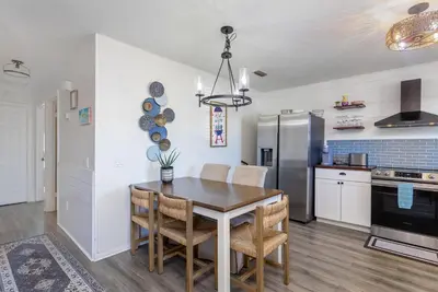 a kitchen with a table and chairs and a refrigerator at Beachside Bliss - Breakfast, Walk to Schooners, Sleeps 15, Fenced Privacy in Panama City Beach