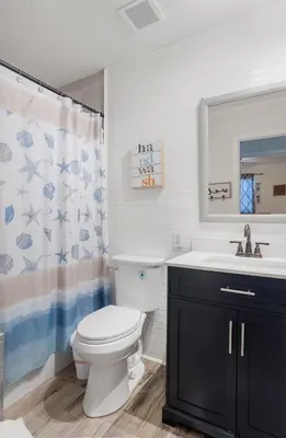 a bathroom with a toilet and a sink at Beachside Bliss - Breakfast, Walk to Schooners, Sleeps 15, Fenced Privacy in Panama City Beach