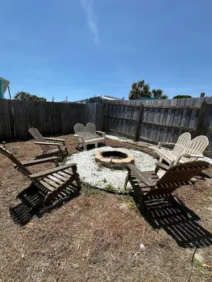 a group of chairs and a fire pit in a yard at Beachside Bliss - Breakfast, Walk to Schooners, Sleeps 15, Fenced Privacy in Panama City Beach