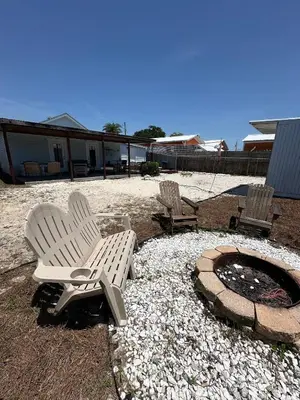 two chairs and a fire pit in a yard at Beachside Bliss - Breakfast, Walk to Schooners, Sleeps 15, Fenced Privacy in Panama City Beach