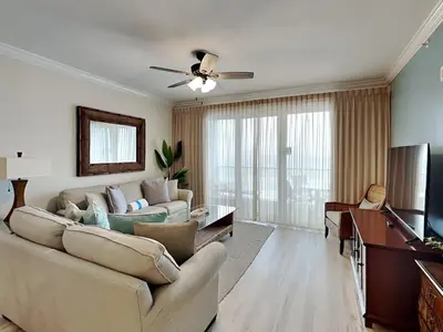 a living room with a couch and a ceiling fan at Grandview East #403 in Panama City Beach