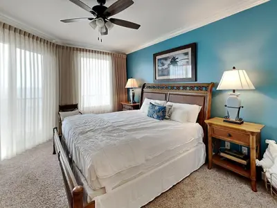 a bedroom with a large bed with a ceiling fan at Grandview East #403 in Panama City Beach