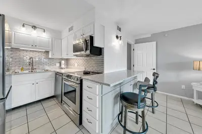 a kitchen with white cabinets and a stove top oven at The Summit 126 in Panama City Beach