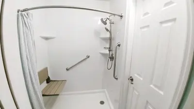 a white bathroom with a shower and a white door at The Summit 126 in Panama City Beach