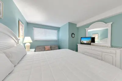 a bedroom with a white bed and a television at The Summit 126 in Panama City Beach