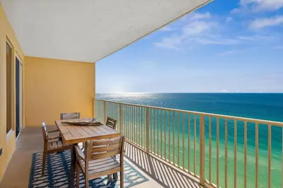 a balcony with a table and chairs and the ocean at Treasure Island #1207 in Panama City Beach