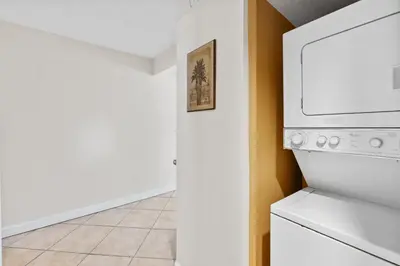 a kitchen with a microwave and a washer and dryer at Aquavista Condominiums #205-W by Book That Condo in Panama City Beach