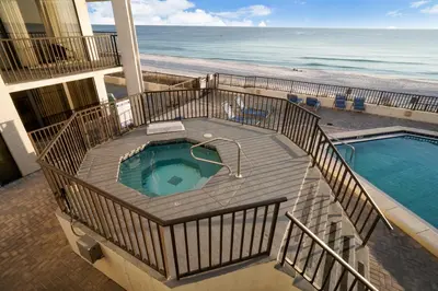 a deck with a swimming pool next to the beach at Aquavista Condominiums #205-W by Book That Condo in Panama City Beach