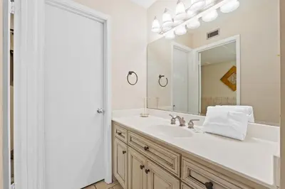 a white bathroom with a sink and a mirror at Aquavista Condominiums #204-W by Book That Condo in Panama City Beach