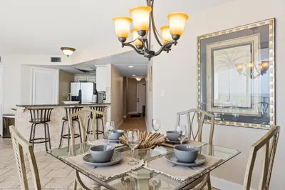 a dining room with a glass table and chairs at Aquavista Condominiums #204-W by Book That Condo in Panama City Beach
