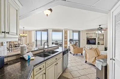 a kitchen and living room with a view of the ocean at Aquavista Condominiums #204-W by Book That Condo in Panama City Beach