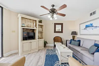 a living room with a couch and a ceiling fan at Aquavista Condominiums #204-W by Book That Condo in Panama City Beach