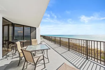 a balcony with tables and chairs and the ocean at Aquavista Condominiums #204-W by Book That Condo in Panama City Beach