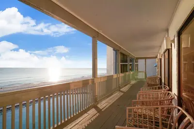 a balcony with chairs looking out at the ocean at Aquavista Condominiums #204-W by Book That Condo in Panama City Beach