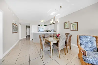 a dining room and living room with a table and chairs at Celadon 302 in Panama City Beach
