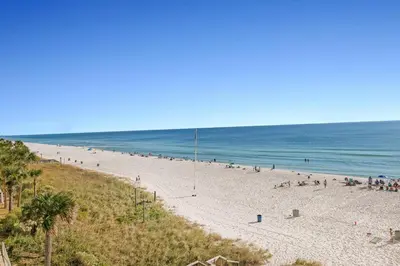 a group of people on a beach with the ocean at Celadon 302 in Panama City Beach