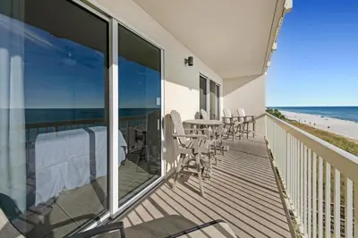 a balcony with a table and chairs on the beach at Celadon 302 in Panama City Beach