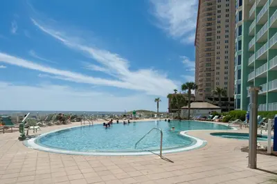 a swimming pool at a resort with people in it at Emerald Beach Resort 2235 in Panama City Beach