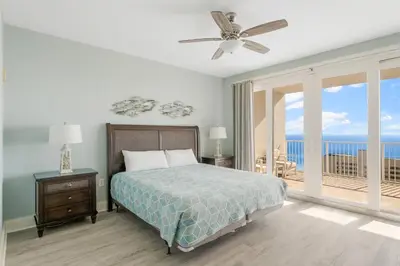a bedroom with a bed and a balcony with the ocean at Laketown Wharf #1612 by Nautical Properties in Panama City Beach