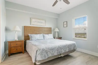 a white bedroom with a bed and a window at Laketown Wharf #1612 by Nautical Properties in Panama City Beach
